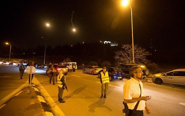 Soldiers, police and civilians block the entrance of the Otniel settlement in the southern West Bank on January 17, 2016. (AFP / MENAHEM KAHANA) Soldiers, police and civilians block the entrance of the Otniel settlement in the southern West Bank on January 17, 2016. (AFP / MENAHEM KAHANA)