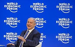 Prime Minister Benjamin Netanyahu laughs during a conference at the World Economic Forum (WEF) annual meeting in Davos,  on January 21, 2016. (AFP/FABRICE COFFRINI)