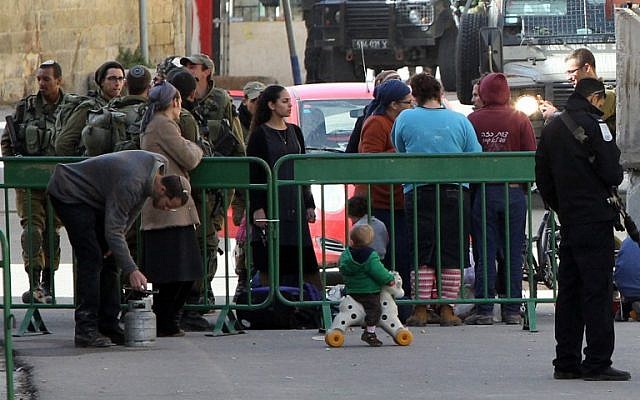 Jewish settlers gather their belongings as they are evacuated by Israeli security forces from two homes in the West Bank city of Hebron on January 22, 2016. (AFP / HAZEM BADER) Jewish settlers gather their belongings as they are evacuated by Israeli security forces from two homes in the West Bank city of Hebron on January 22, 2016. (AFP / HAZEM BADER)