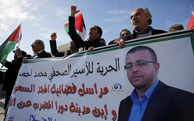 Palestinians take part in a demonstration near Ramallah demanding the release of Palestinian journalist Mohammed al-Qiq (portrait) from an Israeli jail, January 22, 2016. (Abbas Momani/AFP)