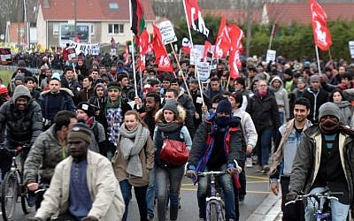 People take part in a demonstration to support migrants who live in a migrant camp on the edge of town, nicknamed the "Jungle" on January 23, 2016 in the French port city of Calais, northern France. (Francois Lo Presti/AFP)