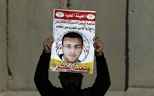 Photo taken on January 22, 2016, shows a Palestinian man carrying a placard bearing a portrait of Palestinian journalist Mohammed al-Qiq during a demonstration near Ramallah demanding his release from an Israeli jail. (Abbas Momani/AFP, File) Photo taken on January 22, 2016, shows a Palestinian man carrying a placard bearing a portrait of Palestinian journalist Mohammed al-Qiq during a demonstration near Ramallah demanding his release from an Israeli jail. (Abbas Momani/AFP, File)