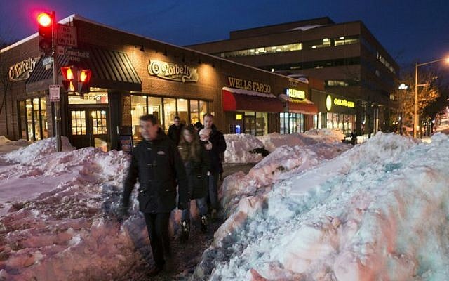 Pedestrians file through a passage between mounds of snow in northwest Washington, DC on January 25, 2016. (Mandel Ngan/AFP)