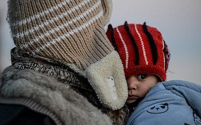 A mother and her child wait after being caught by Turkish gendarme on January 27, 2016 at Kucukkuyu district in Canakkale. (AFP / OZAN KOSE)