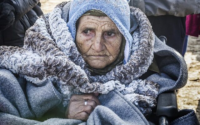 A wheelchair-bound elderly woman arrives along with other migrants and refugees to the village of Miratovac after crossing into Serbia via the Macedonian border on January 28, 2016.(AFP / ARMEND NIMANI)