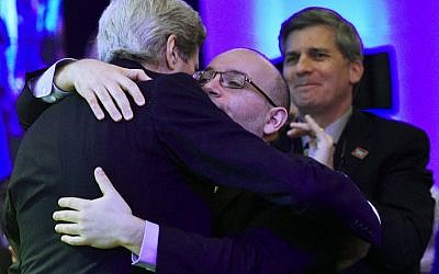 Freed Washington Post Tehran bureau chief Jason Rezaian (R) receives a hug from US Secretary of State John Kerry (C) during the inauguration of the Washington Post Headquarters on January 28, 2016 in Washington, DC. (AFP / Mandel Ngan)