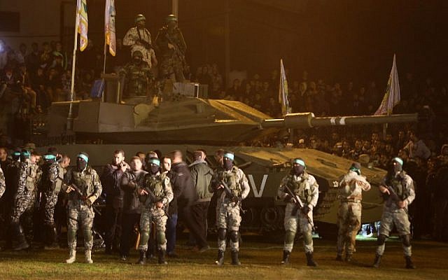 Palestinian members of the armed wing of the Hamas movement gather around a mock Israeli tank on January 31, 2016 in Gaza city during a gathering to pay tribute to Gazans who died in a tunnel collapse. (AFP / MAHMUD HAMS) Palestinian members of the armed wing of the Hamas movement gather around a mock Israeli tank on January 31, 2016 in Gaza city during a gathering to pay tribute to Gazans who died in a tunnel collapse. (AFP / MAHMUD HAMS)
