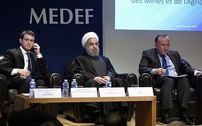 Iranian President Hassan Rouhani, center  sits next French Prime Minister Manuel Valls, left, and Head of French employers association Medef head Pierre Gattaz during a meeting at the MEDEF headquarters in Paris, January 28, 2016. (AFP/ERIC FEFERBERG)