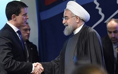French Prime Minister Manuel Valls (L) shakes hands with Iranian President Hassan Rouhani on January 28, 2016 during a meeting at the  French employers association MEDEF headquarters in Paris. (AFP/ERIC FEFERBERG)