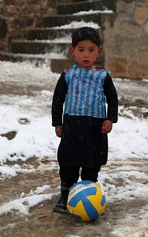 Afghan boy and Lionel Messi fan Murtaza Ahmadi, 5, wears a plastic bag jersey as he plays soccer in Jaghori district of Ghazni province on January 29, 2016. (AFP)