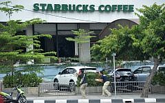 Plainclothes police aim their handguns towards suspects outside a cafe after a series of blasts hit the Indonesia capital Jakarta on January 14, 2016. (AFP PHOTO / Bay ISMOYO)