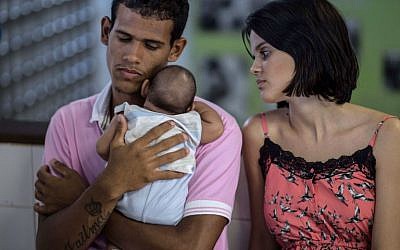 Matheus Lima, 22, and Kleisse Marcelina, 24, tend their two-month-old son Pietro suffering from microcephalia caught through an Aedes aegypti mosquito bite, at the Obras Sociais Irma Dulce hospital in Salvador, Brazil on January 27, 2016. (AFP PHOTO/Christophe SIMON)