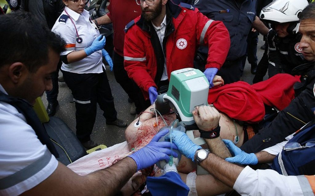 Medics give emergency treatment to a victim following an attack by an unidentified gunman in central Tel Aviv that killed two people and wounded seven others on January 1, 2016. (AFP PHOTO/JACK GUEZ)