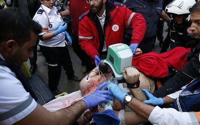 Medics give emergency treatment to a victim following an attack by an unidentified gunman in central Tel Aviv that killed two people and wounded seven others on January 1, 2016. (AFP PHOTO/JACK GUEZ)