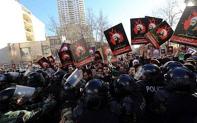 Iranian protesters hold portraits of prominent Shiite Muslim cleric Nimr al-Nimr as they confront riot police during a demonstration against his execution by Saudi authorities on January 3, 2016, outside the Saudi embassy in Tehran. (AFP/Atta Kenare)