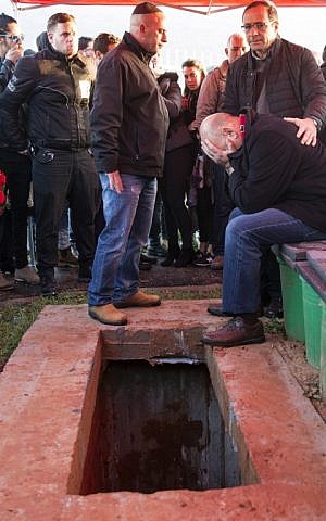 The father and relatives of 26-year-old Alon Bakal, who was murdered in a shooting attack at in Tel Aviv of New Year's Day, mourn next to his grave during his burial om Carmiel on January 3, 2016. (AFP PHOTO/JACK GUEZ)
