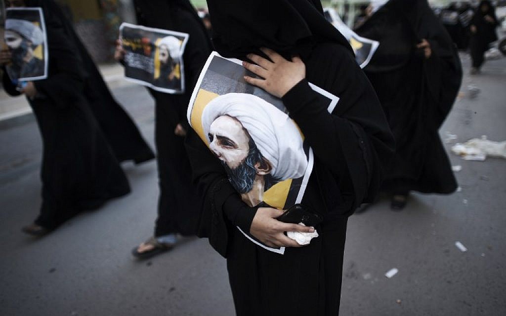 Bahraini women hold posters bearing portraits of prominent Shiite Muslim cleric Nimr al-Nimr during a protest against his execution by Saudi authorities, in the village of Jidhafs, west of the capital Manama on January 3, 2016. (Mohammed al-Shaikh/AFP)