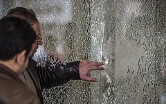 Egyptian forensic experts inspect a bullet-riddled window at the entrance of the Three Pyramids hotel in Cairo where Israeli tourists were shot at, January 7, 2016. (AFP Photo/ Khaled Desouki)