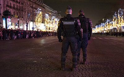Police patrol ahead of New Year's celebrations on the Champs-Elysees, just before midnight in Paris on December 31, 2015. (AFP Photo/Florian David)
