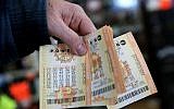 A customer holds a handful of Powerball tickets at Kavanagh Liquors on January 13, 2016 in San Lorenzo, California. (Justin Sullivan/Getty Images/AFP)