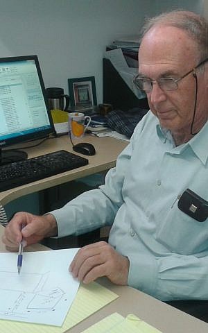 Dr. Avi Ramot, director of the Israel Center for Accessibility, reviews plans for protected bus stops. (Shekel)
