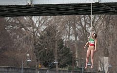 An activist hangs from a noose-like rope from a Paris bridge to call attention to the large number of executions in Iran,  January 28, 2016. (AP Photo/Zacharie Scheurer)