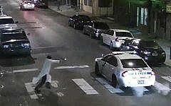 In this frame from a Thursday, Jan. 7, 2016 video provided by the Philadelphia Police Department, Islamic State-inspired Edward Archer, 30, runs with a gun toward a police car driven by Officer Jesse Hartnett, 33, in Philadelphia. (Philadelphia Police Department via AP)