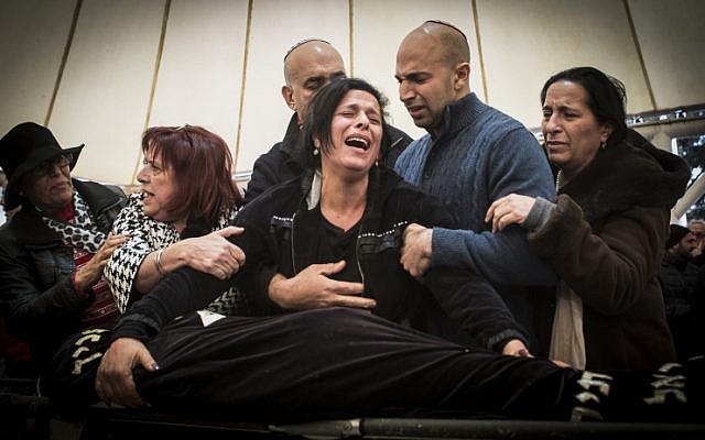 Family and friends of Alon Bakal cry at his funeral in the northern Israeli city of Carmiel on January 3, 2015. (Basel Awidat/Flash90)