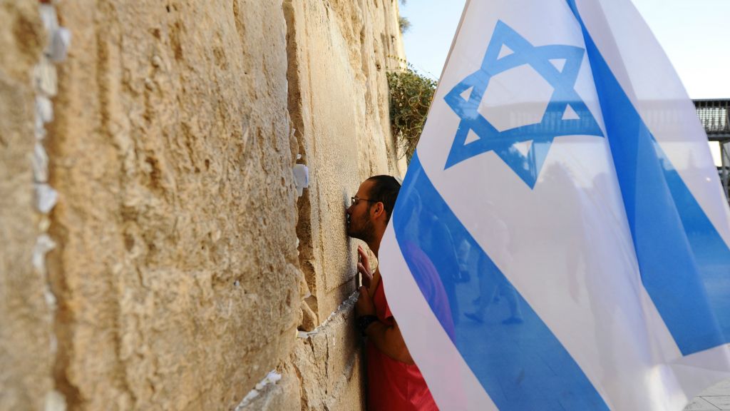 A man holds an Israeli flag during a march in support of the city of Jerusalem at the Western Wall, in Jerusalem's Old City on October 22, 2015, following a wave of terror attacks. (Mendy Hechtman/Flash90) A man holds an Israeli flag during a march in support of the city of Jerusalem at the Western Wall, in Jerusalem's Old City on October 22, 2015, following a wave of terror attacks. (Mendy Hechtman/Flash90)