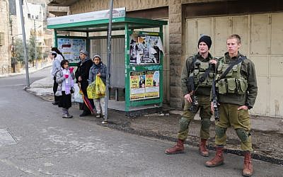Israeli security forces stand guard next to a bus station in Hebron in the West Bank on December 13, 2015. (Gershon Elinson/Flash90)