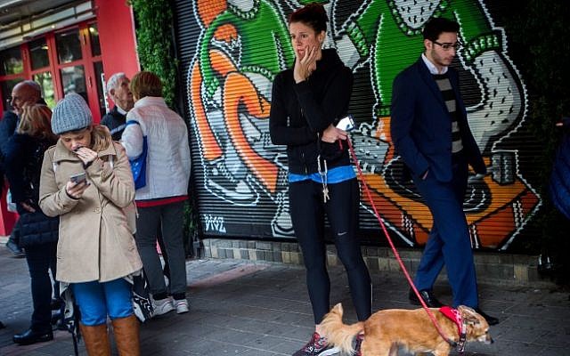 Israelis outside a bar on Dizengoff Street in central Tel Aviv on January 2, 2016, a day after two people were killed and 6 injured in a shooting at the bar (Miriam Alster/Flash90)