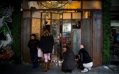 Israelis light candles at the Simta bar on Dizengoff Street in central Tel Aviv, on January 02, 2016, a day after two people were killed in a shooting there. (Miriam Alster/Flash90)