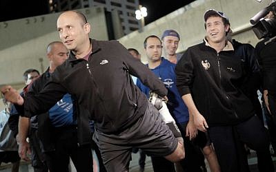 Education Minister Naftali Bennett warms up before a night run in central Tel Aviv on Monday, January 4, 2016, in a bid to inspire courage in the hearts of the city's residents two days after a deadly shooting attack (Tomer Neuberg/Flash90)