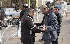 Israeli security forces frisk Arab Israelis near the Central Bus Station in Herzliya on January 5, 2016. (Tomer Neuberg/Flash90)