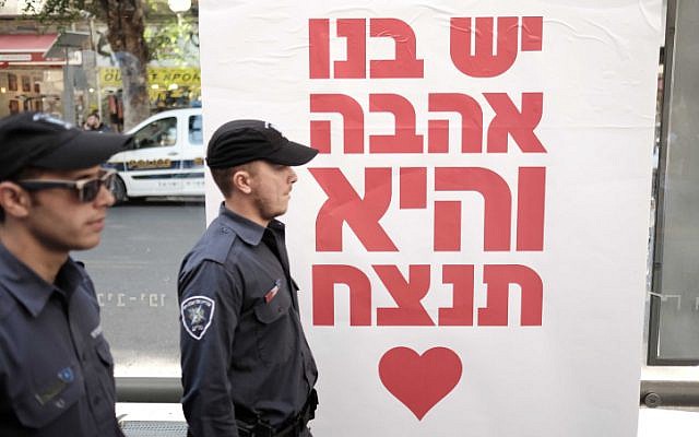 Police officers stand by a poster reading: 'We have love in us, and it will win,' at a street party on January 15, 2016 at the Simta bar in Tel Aviv, where two weeks ago two Israelis were killed in a shooting attack. (Photo by Tomer Neuberg/FLASH90) Police officers stand by a poster reading: 'We have love in us, and it will win,' at a street party on January 15, 2016 at the Simta bar in Tel Aviv, where two weeks ago two Israelis were killed in a shooting attack. (Photo by Tomer Neuberg/FLASH90)