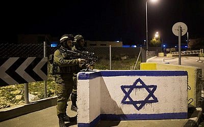 Israeli soldiers stand guard at a junction in the West Bank on January 17, 2015. (Yonatan Sindel/Flash90)