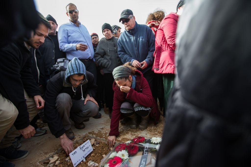 People mourn over the fresh grave of Dafna Meir, during her funeral in Jeursalem on January 18, 2016. (Yonatan Sindel/Flash90) People mourn over the fresh grave of Dafna Meir, during her funeral in Jeursalem on January 18, 2016. (Yonatan Sindel/Flash90)