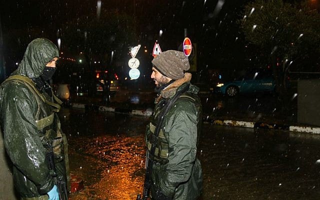 IDF soldiers stand guard in the cold near the Gush Etzion Junction on January 24, 2016, as a major winter storm hits the country. (Gershon Elinson/Flash90)