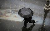 People walk with umbrellas in central Jerusalem as light snow begins to fall, January 25, 2016. (Hadas Parush/Flash90)