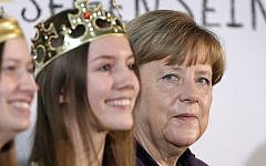 German Chancellor Angela Merkel, right, poses with carolers during a reception for carol singers from all over Germany at the chancellery in Berlin, Germany, Tuesday, Jan. 5, 2016. (AP Photo/Michael Sohn)