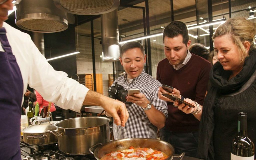 Vibe food bloggers Luiz Hara, Manu Balanzino and Sam Linsell watch Israeli chef Avner Laskin saute locally-grown cherry tomatoes (Courtesy Chaim Yosef) Vibe food bloggers Luiz Hara, Manu Balanzino and Sam Linsell watch Israeli chef Avner Laskin saute locally-grown cherry tomatoes (Courtesy Chaim Yosef)