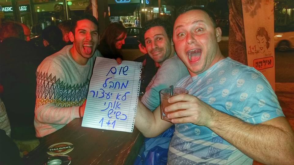 Patrons at Ilka Bar sit with their drinks and a sign that reads: "No terrorist will stop me when there's 1+1" (Courtesy Ilka Bar)