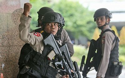 A police officer gives a hand signal to a squad mate as they search a building near the site of an explosion in Jakarta, Indonesia, January 14, 2016. (AP/Tatan Syuflana)