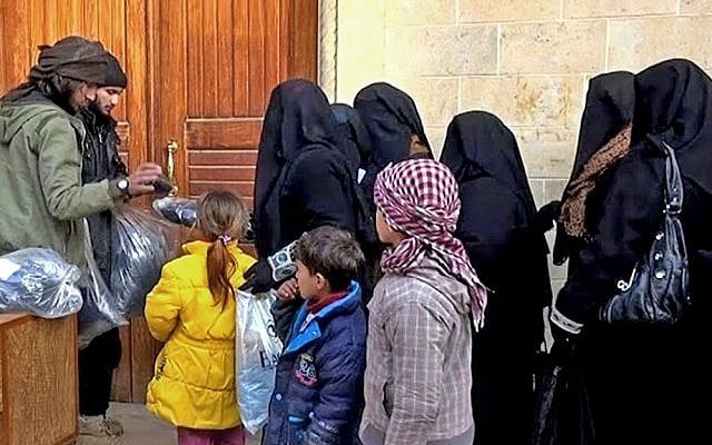 Members of the Islamic State group distribute niqabs and veils to Iraqi women in Mosul, northern Iraq, January 31, 2014. (Militant website via AP, File) Members of the Islamic State group distribute niqabs and veils to Iraqi women in Mosul, northern Iraq, January 31, 2014. (Militant website via AP, File)