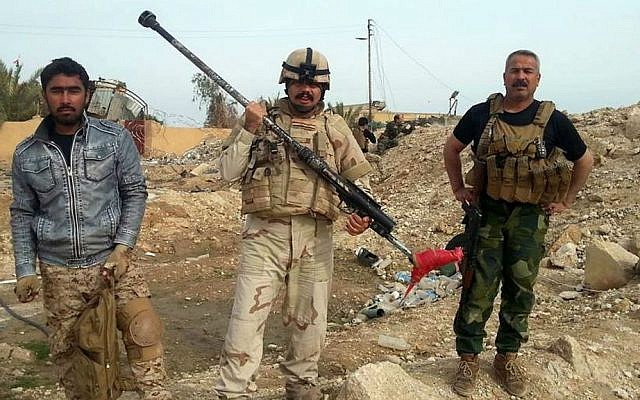 Iraqi security forces and allied Sunni tribal fighters display weapons used by Islamic State militants to attack their city in Haditha, 240 kilometers (150 miles) northwest of Baghdad, Iraq, Tuesday, Jan. 5, 2016. (AP Photo)