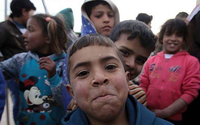 Syrian refugee children pose for a picture during a visit by the new chief of the UN refugee agency, Filippo Grandi, at the Zaatari refugee camp, Mafraq, Jordan, Monday, Jan. 18, 2016. (AP Photo/Raad Adayleh)
