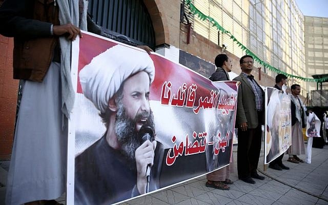 Houthi Shiite rebels hold posters of late cleric Nimr al-Nimr, who was executed in Saudi Arabia, during an anti-Saudi protest outside the Saudi embassy in Sanaa, Yemen, Thursday, January 7, 2016. (AP Photo/Hani Mohammed)