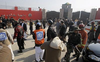 Pakistani troops and rescue workers gather at the main gate of Bacha Khan University in Charsadda town, some 35 kilometers (21 miles) outside the city of Peshawar, Pakistan, Wednesday, January 20, 2016. (AP Photo/Mohammad Sajjad)