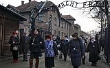 Holocaust survivors walk with others through the main gate of the former Nazi death camp Auschwitz in Poland, on January 27, 2016 (AP/Czarek Sokolowski)