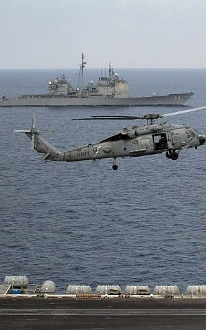 A US Navy helicopter approaching to land on the deck of the US Navy aircraft carrier USS Theodore Roosevelt as the USS Normady sails nearby during Exercise Malabar 2015 about 150 miles off Chennai, India, October 17, 2015. (AP/Arun Sankar K., File) 